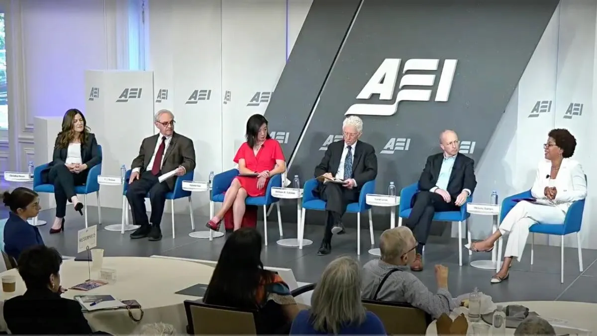 A group of 6 panelists on stage at an event